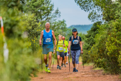 un groupe de personnes marchent avec des bâtons de marche nordique sur un sentier de terre arboré - Agrandir l'image 14 sur 21, fenêtre modale