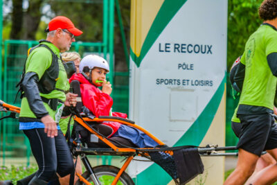 une joélette de l'association tehani et les enfants phelan mac dermid prend le départ de la course 6km - Agrandir l'image 8 sur 33, fenêtre modale