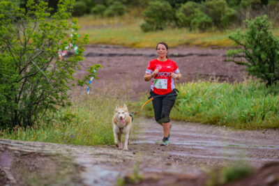 coureuse canicross avec son chien sur piste nature pendant la course - Agrandir l'image 6 sur 33, fenêtre modale