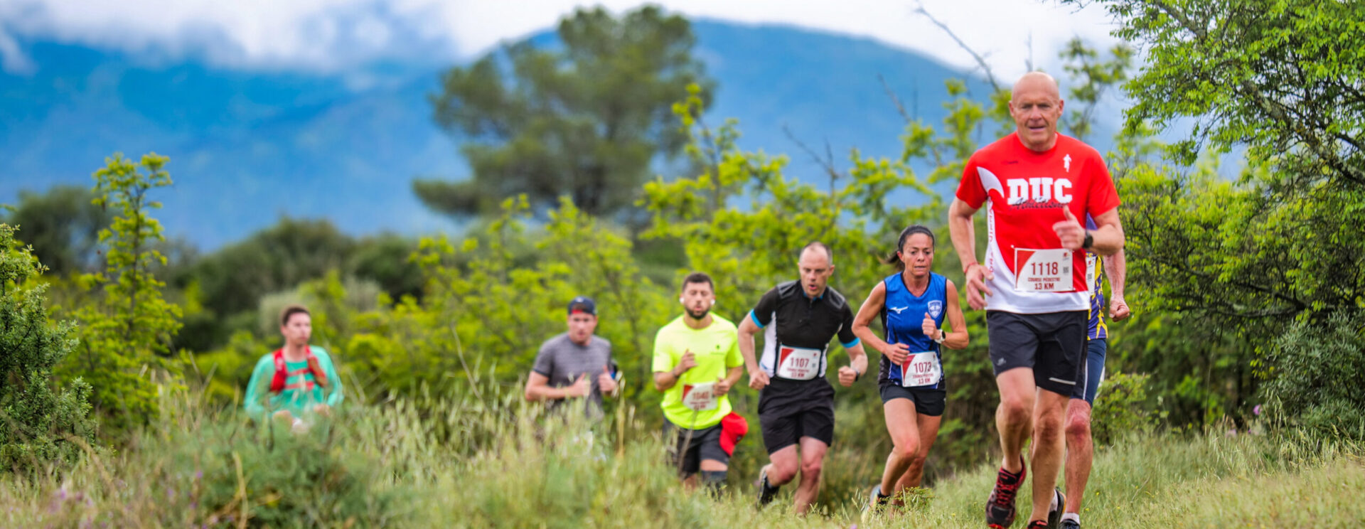un groupe de coureurs passent un chemin de terre pendant la course